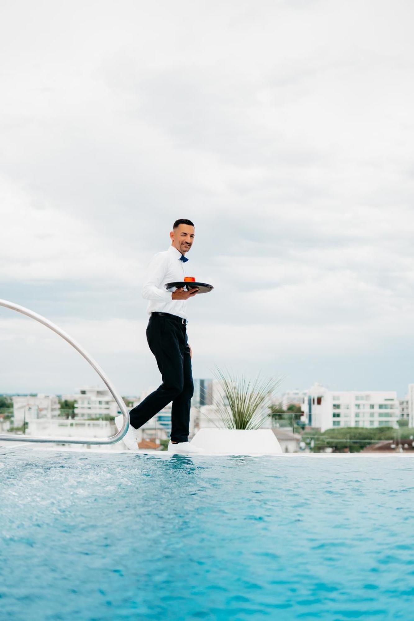 J44 Lifestyle Hotel Lido di Jesolo Exterior foto A waiter balancing on a tightrope