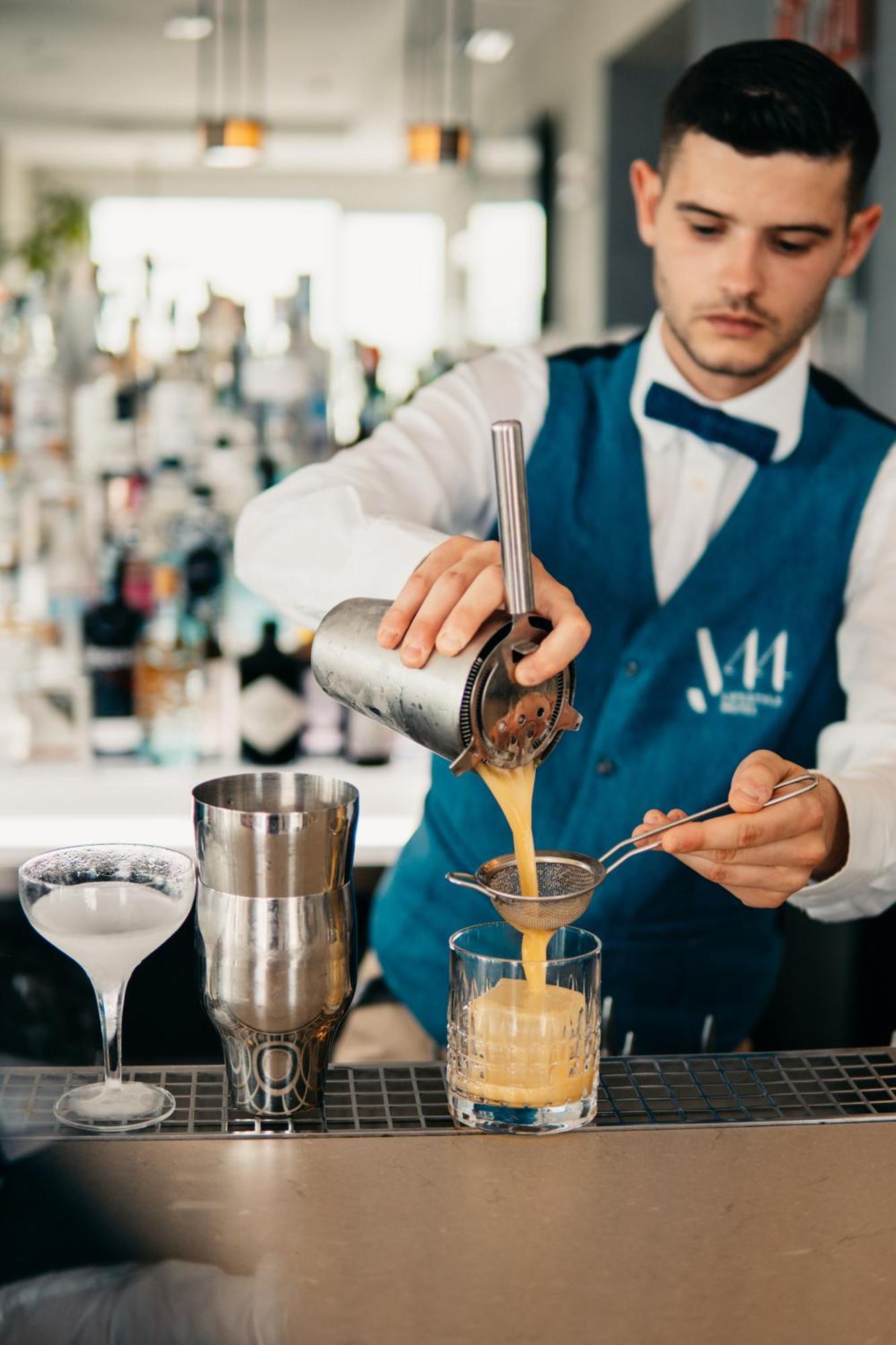 J44 Lifestyle Hotel Lido di Jesolo Exterior foto A bartender straining a cocktail